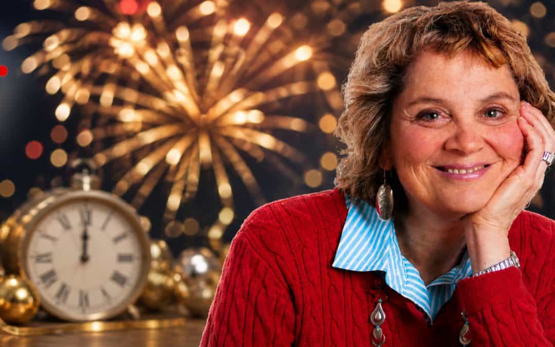 Woman smiling during New Year celebration with fireworks, clock, and festive decorations, symbolizing reflection and new beginnings for the year ahead.