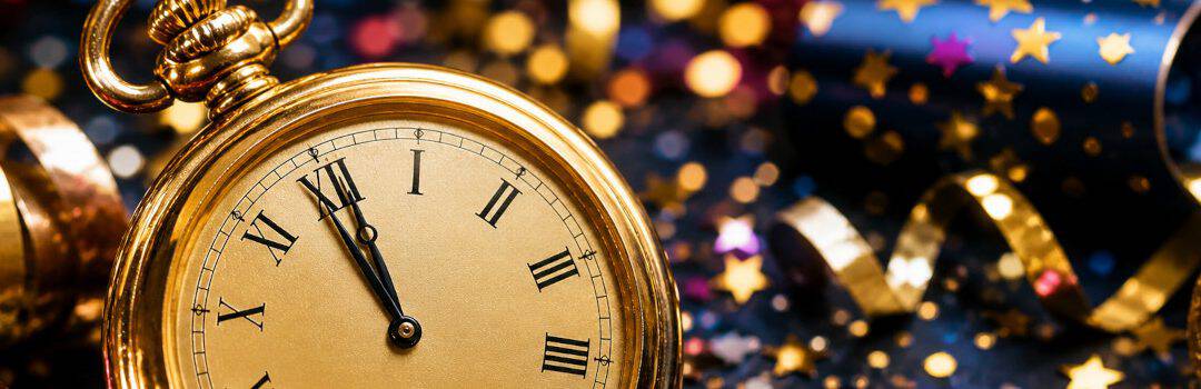 Close-up of a gold clock showing almost midnight, surrounded by New Year party decorations like confetti and streamers, symbolizing celebration and new beginnings.