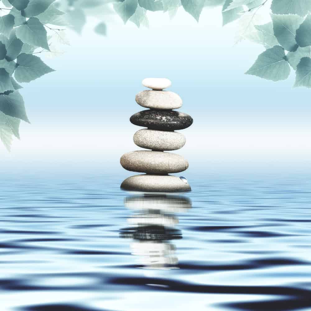 Peaceful image of stacked stones balanced on water with calm ripples, symbolizing harmony, mindfulness, and inner peace. Perfect for wellness, meditation, and mindfulness themes.