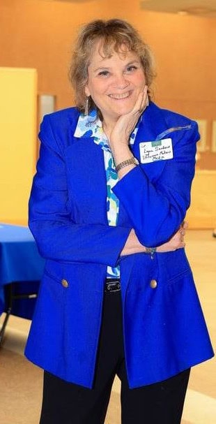 Bright, smiling woman in professional blue blazer at a Difference Makers Media event, showcasing leadership, networking, and community engagement.