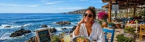 Woman enjoying a seaside meal at a vibrant outdoor restaurant, emphasizing authentic communication and personal voice in messaging strategies.