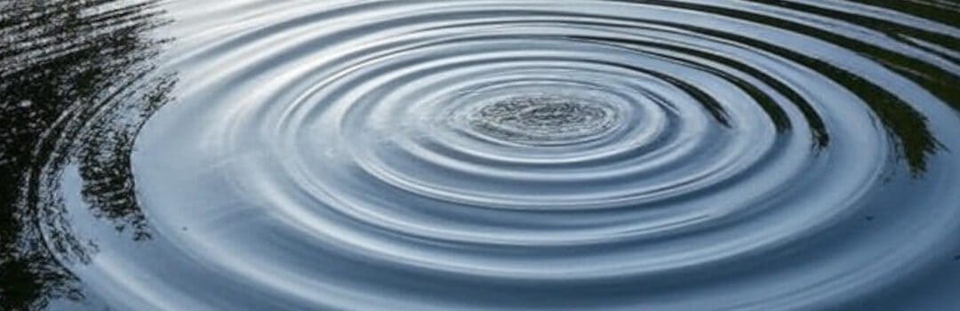Ripple effect on calm water surface representing impact and influence in media and communication.