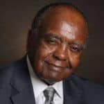 A man in a suit with a confident expression, representing leadership and success.