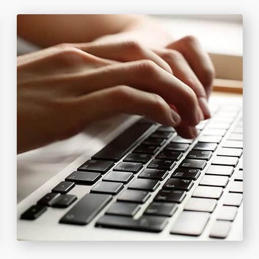 Close-up of hands typing on a laptop keyboard, symbolizing story empowerment and digital communication.